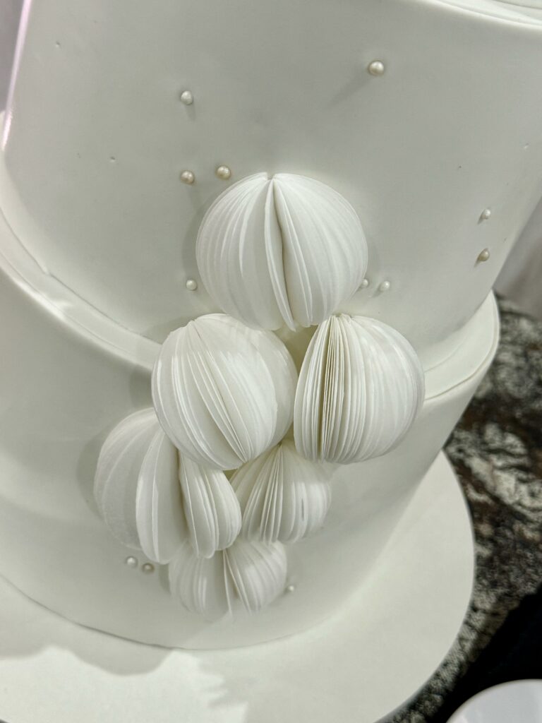 white wedding cake with wafer paper spheres
